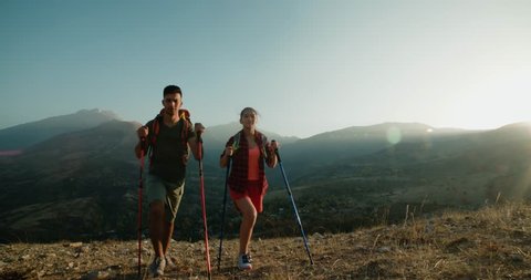 young Asian couple Hiking in the mountains on Sunny day, steadycam shot