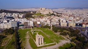 Aerial birds eye view video taken by drone of iconic pillars of temple of Zeus and Acropolis hill at the background, Athens historic center, Attica, Greece