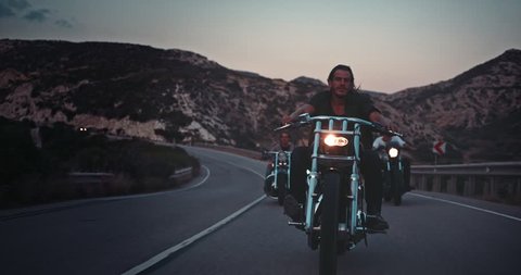 Young macho bikers riding motorbikes on mountain highway at sunset during road trip adventure Stock Video