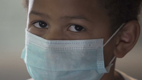 African boy wearing medical mask and looking at camera, infection, healthcare