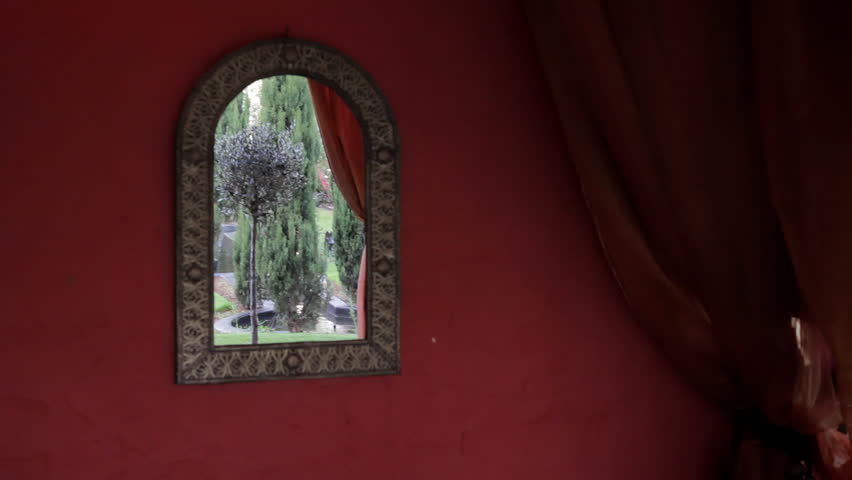 a mirror reflecting a garden from a villa