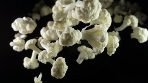 Cauliflower falls in the air on a black background. slow motion.
