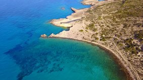 Aerial drone bird's eye video of famous rocky seascape of Koufonisi island with caves and turquoise - sapphire clear waters, Cyclades, Greece