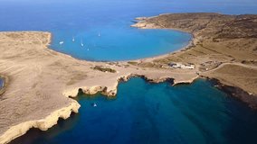 Aerial drone view video of beautiful volcanic caves of Xylobatis or Ksylobatis near famous beach of Pori with deep blue waters, Koufonissi island, Cyclades, Greece