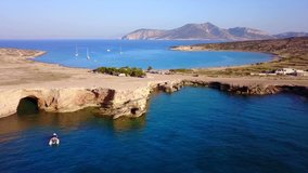 Aerial drone bird's eye video of famous rocky seascape of Koufonisi island with caves and turquoise - sapphire clear waters, Cyclades, Greece
