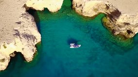Aerial drone view video of beautiful volcanic caves of Xylobatis or Ksylobatis with deep blue waters, Koufonissi island, Cyclades, Greece