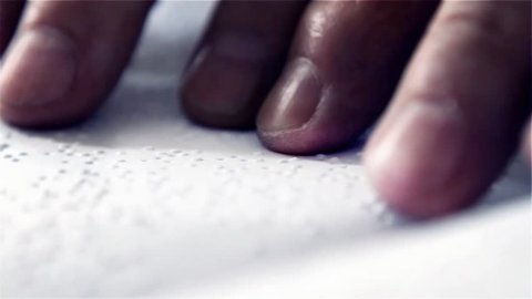 Blind Man Reading a Book Written In Braille. Close Up.