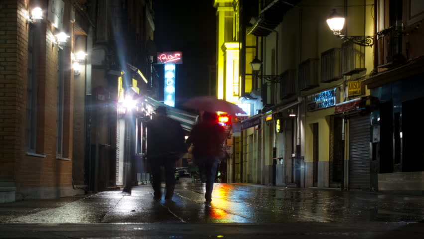 MADRID, SPAIN - CIRCA 2013. Time lapse of people walking in the rain at night in