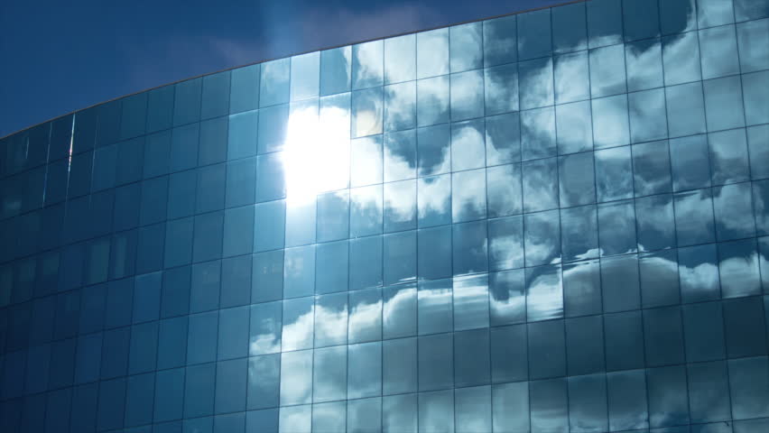Clouds refelected in modern office building. Zoom and panning. 