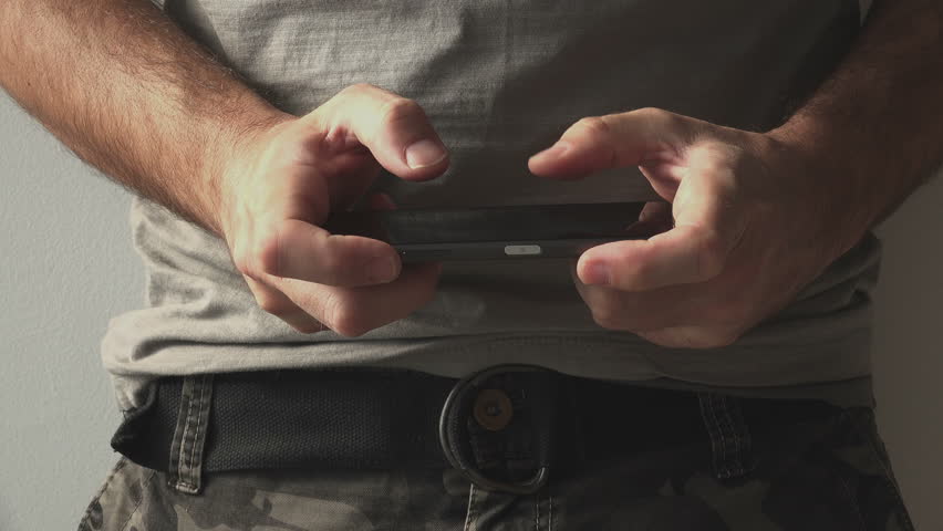 Army soldier playing mobile video game during break