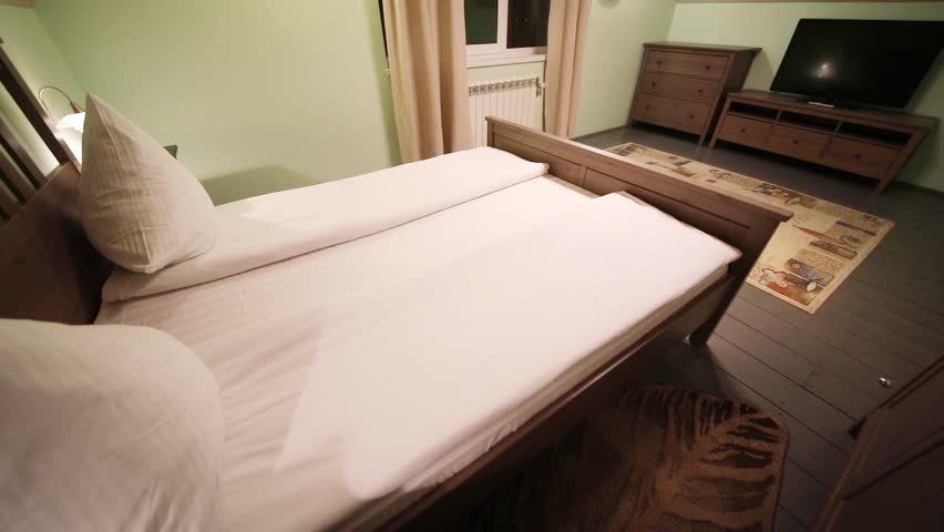 Double bed in front of TV in the attic of the cottage