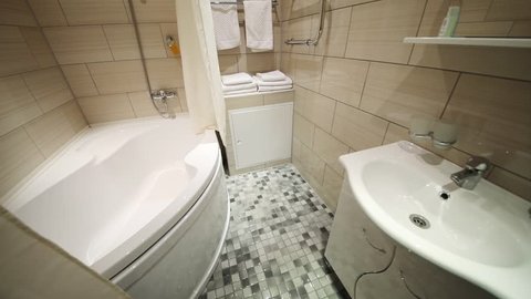 Bath with shower, sink with mirror and towels on holder in bathroom