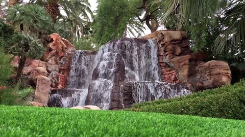 A lush waterfall surrounded by fresh cut grass