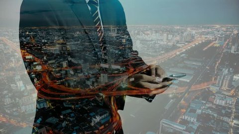 Close up to businessman is using a smartphone and double exposure cityscape communication background, Business about internet of thing concept, 4k resolution. double exposure timelapse.