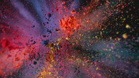 Multi colored powder flying in slow motion as camera pulls away and rotates, shot with high speed motion control.