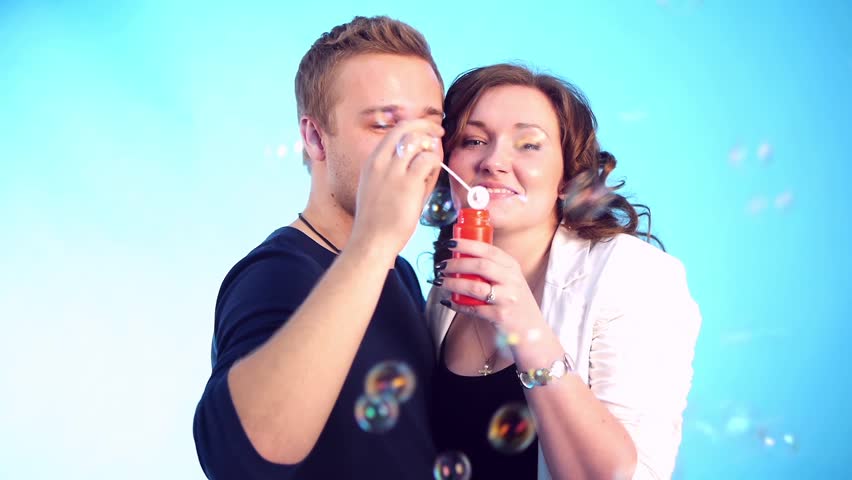 couple blowing bubbles smiling