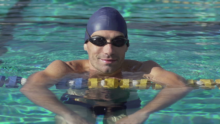 Professional Swimmer Takes A Break In The Lap Pool. Close Shot In Slow Motion.