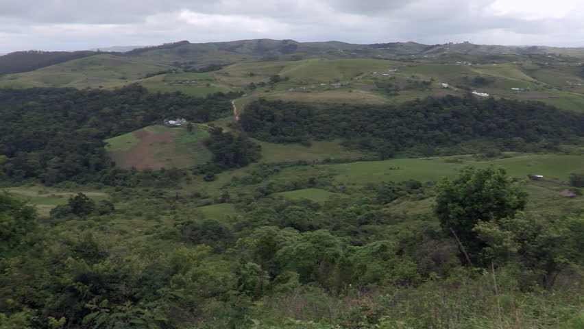Wide pan of rural African valley showing hills,huts and crops in the Transkei.