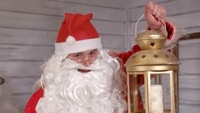 Santa is holding a Christmas golden lantern 