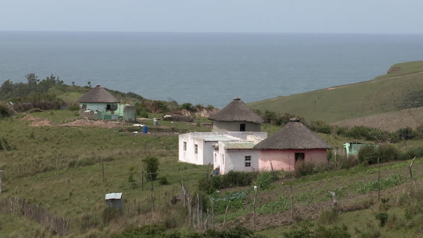 Rural Xhosa farm showing crops, thatched huts and the sea in the background
