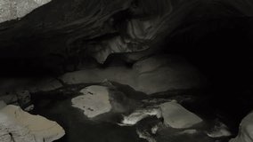 Aerial 4k drone footage of a beautiful river running inside a rocky cave, Huson Caves, in a Canadian Landscape. Video taken in Northern Vancouver Island, British Columbia, Canada.