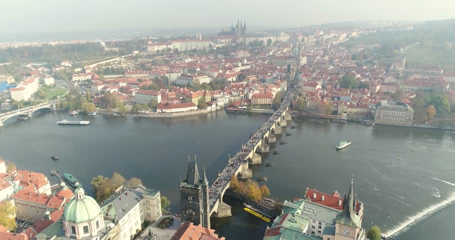 Panoramic view from above on the Charles Bridge over the river in Prague, aerial of the city, view from above on the cityscape of Prague, flight over the city, top view of Charles Bridge, Vltava River