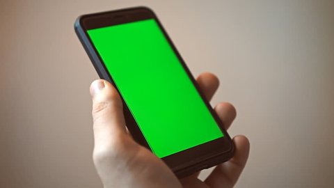 Hand holding mobile phone with green screen. Chroma key.
