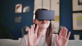 Smiling female hipster using virtual reality simulator at home