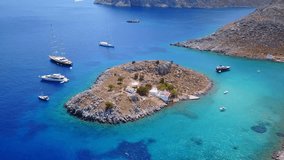 Aerial birds eye view video taken by drone of famous tropical beach of Agia Marina, Symi island, Dodecanese, Greece