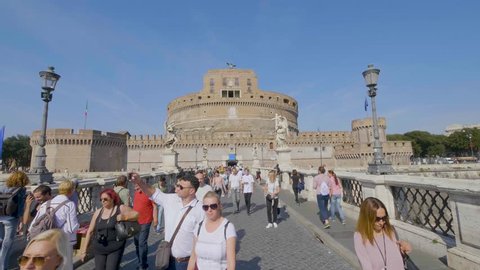 Rome, Italy - June, 2017:  People walking on Ponte Sant Angelo and visiting Castel Sant Angelo.