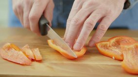 Man's Hands Slicing Red Bell Pepper On Chopping Board
