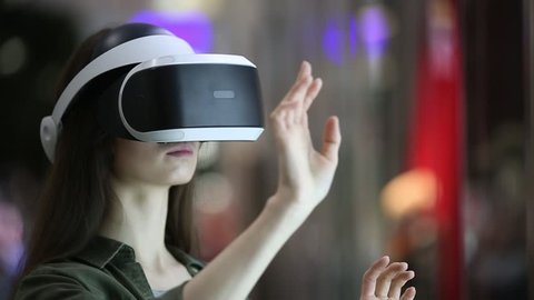 woman uses a virtual reality glasses indoors