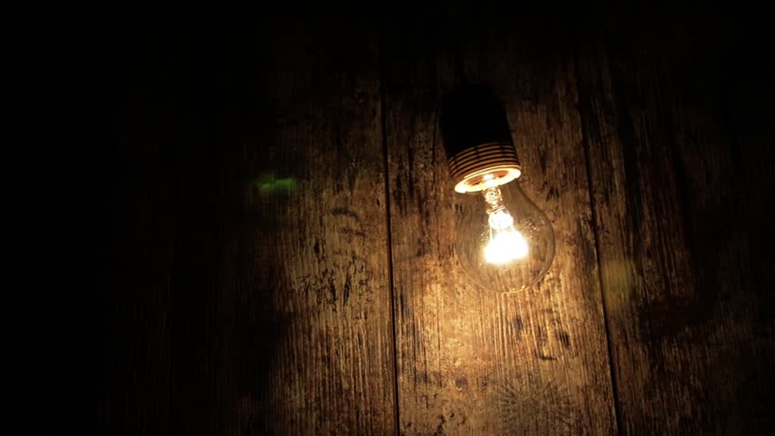 Bulb with different amplitude swinging. Against the background of the old board.