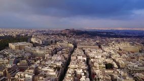 Aerial drone bird's eye video of Athens and iconic Acropolis hill as seen from Lycabettus at dusk, Athens historic center, Attica, Greece