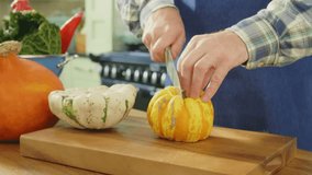 Man Slicing Yellow Pumpkin With Knife On Chopping Board