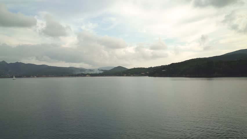 Beautiful green island seen from the sea on overcast weather