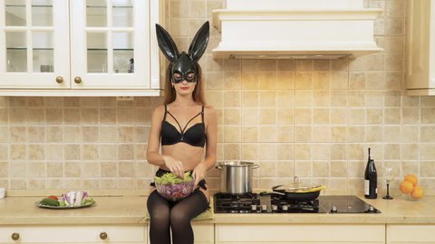 Sexy bunny girl in black lingerie eating the salad