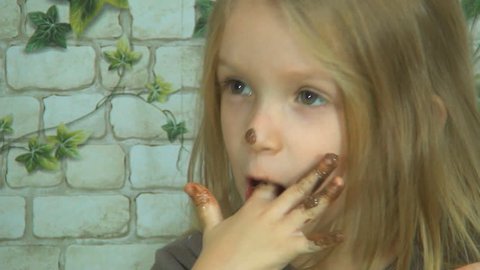 Child Licking Chocolate off her Finger, Little Girl Eating Chocolate