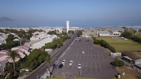 4K high quality aerial video scenic sunny morning view of historical lighthouse area, parking and Table Mountain at the background near beach at sea shore in Milnerton, Cape Town, South Africa