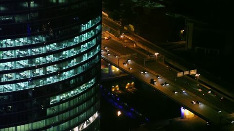 Traffic on street near large office building, view from above at night