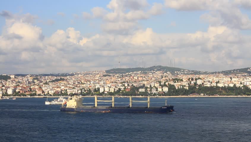 Cargo ship with deck cranes sailing into the sea
