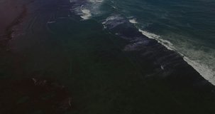 Aerial drone 4k footage of ocean waves breaking before the shore. Bali, Indonesia
