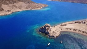 Aerial birds eye view video taken by drone of famous rock of Kalikatsou in Petra beach, Patmos island, Dodecanese, Greece