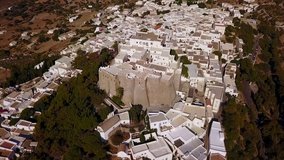 Aerial bird's eye view video taken by drone of Massive fortified stone Monastery of Saint John the Apostle, Patmos island, Greece