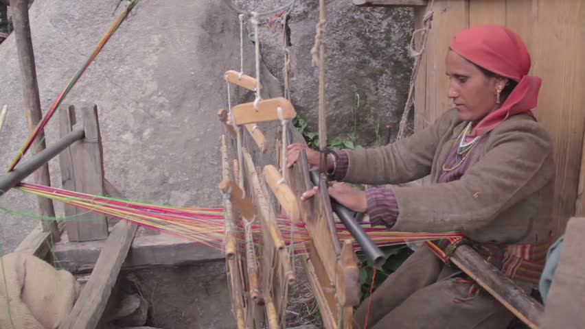 Wide shot of a traditional Pahari woman working on a old wooden hand loom in a remote village situated in Himalayas  Royalty-Free Stock Footage #33384217