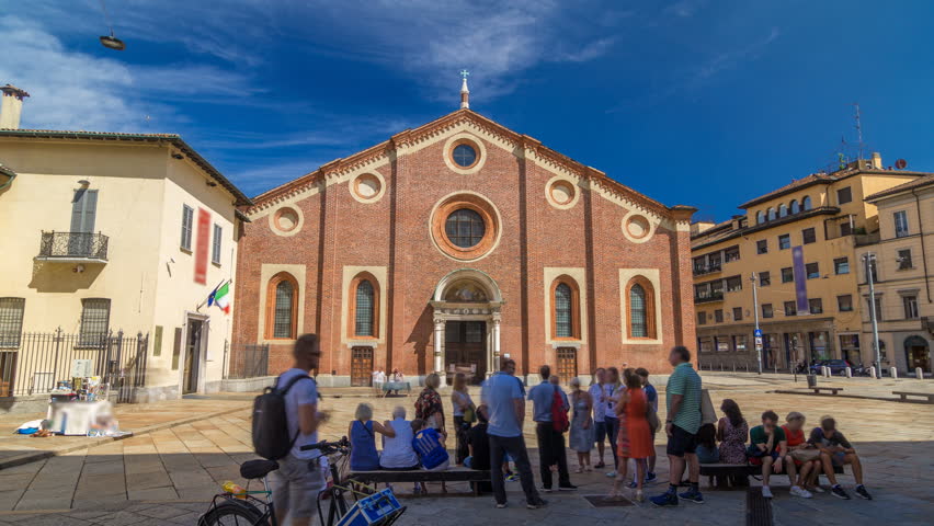 Santa Maria delle Grazie timelapse hyperlapse with blue cloudy sky. Milan, Italy. People sitting on a bench. This church and the adjacent Dominican convent were built during the 15th century.
