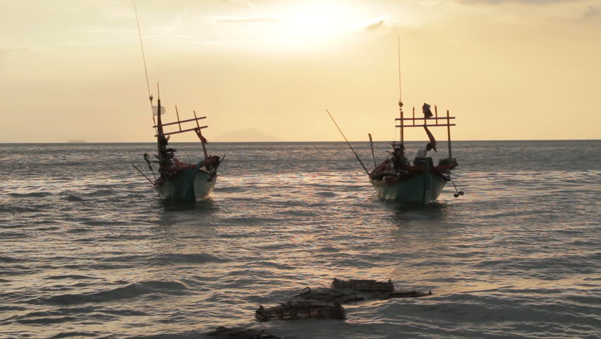   	
two Cambodian  crab fishing boats at sunset 
