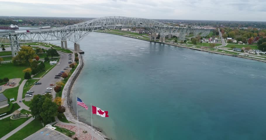 Ontario, Canada - October, 2017: Panning of American and Canadian flags waving in the northern border