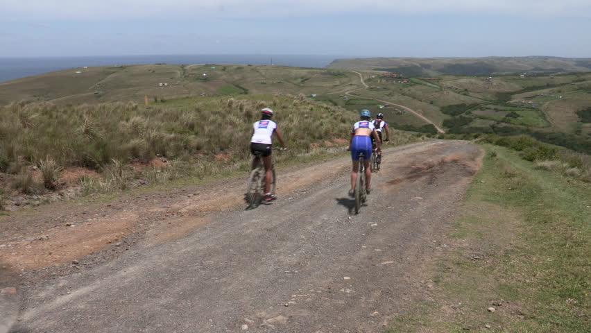 Large group of cyclists cycling through the Transkei Wild Coast, Eastern Cape.