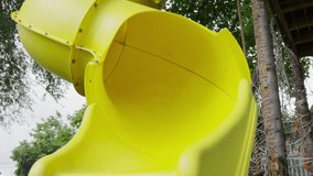 Happy girl sliding on yellow slide at playground / Provo, Utah, United States